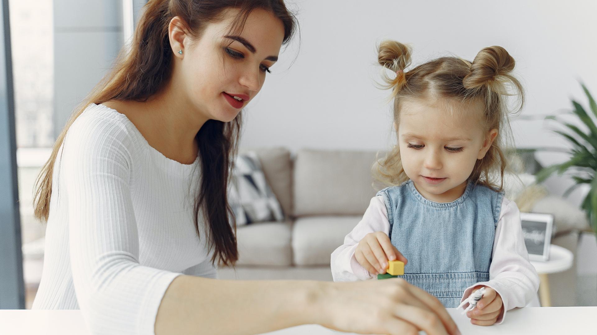 Teenage playing blocks with a child