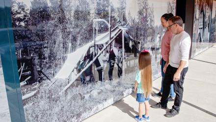 Family observing the Museum's photo mural
