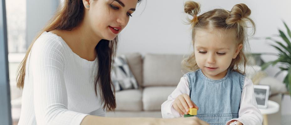 Teenage playing blocks with a child