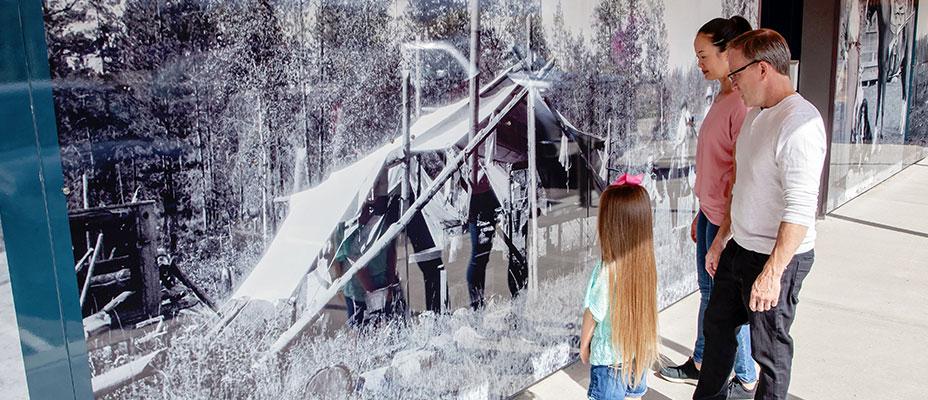 Family observing the Museum's photo mural